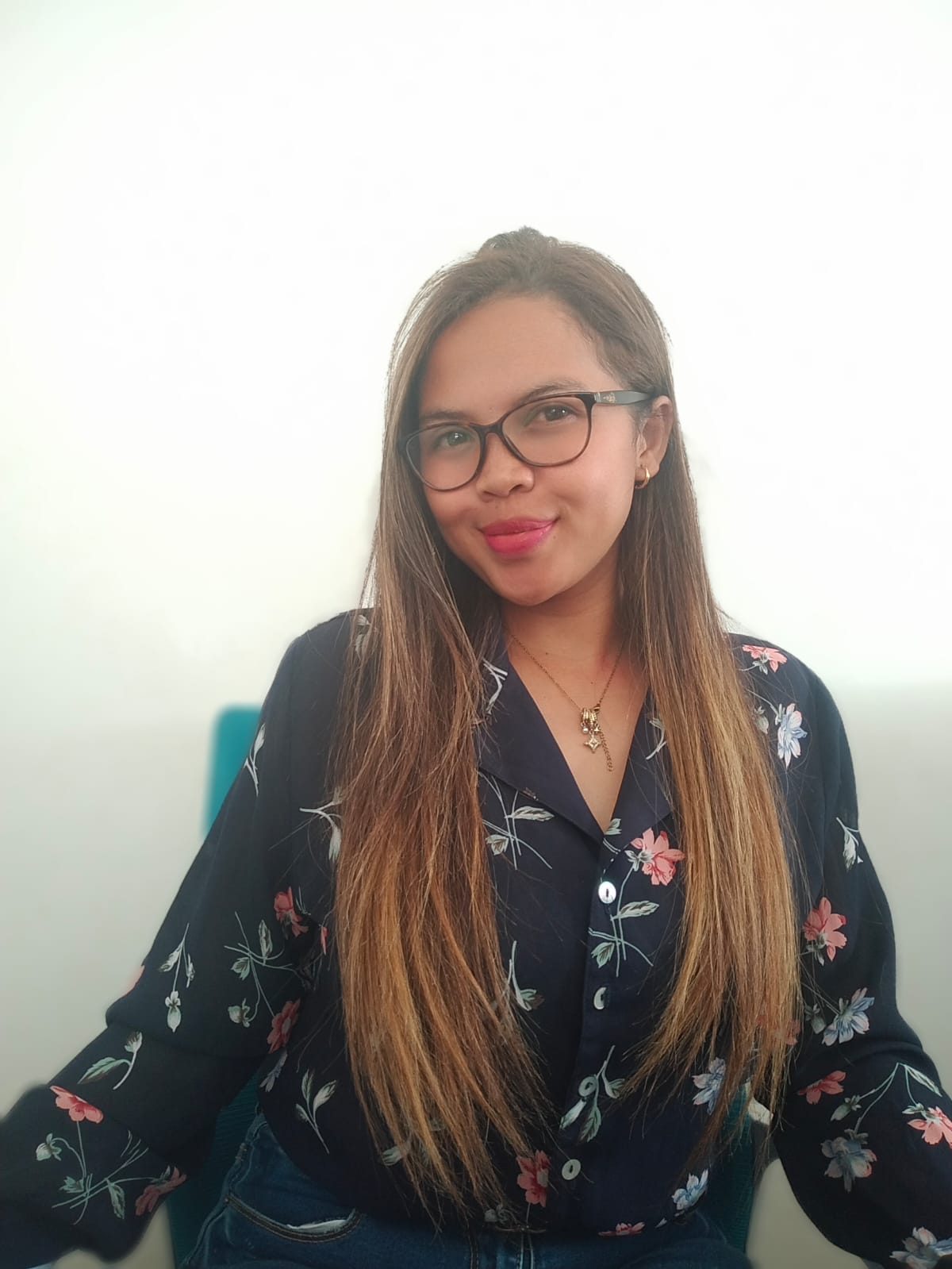 Portrait de Fleurette, souriante, en chemisier sombre à fleurs